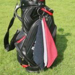 Three Handy Picks 16x16 inch microfiber golf towels in black, grey, and red, with attached carabiner clips, neatly folded.